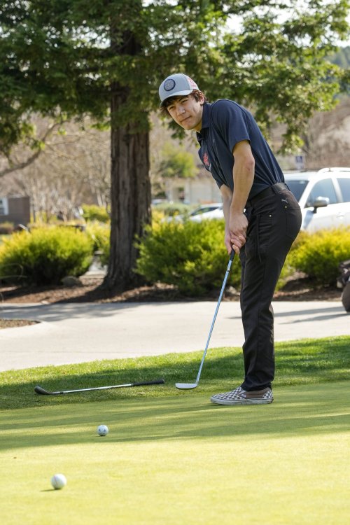 Second year student Matthew Manzi ('26) practices his short game as he gets reps on the practice putting green at Moraga Country Club.