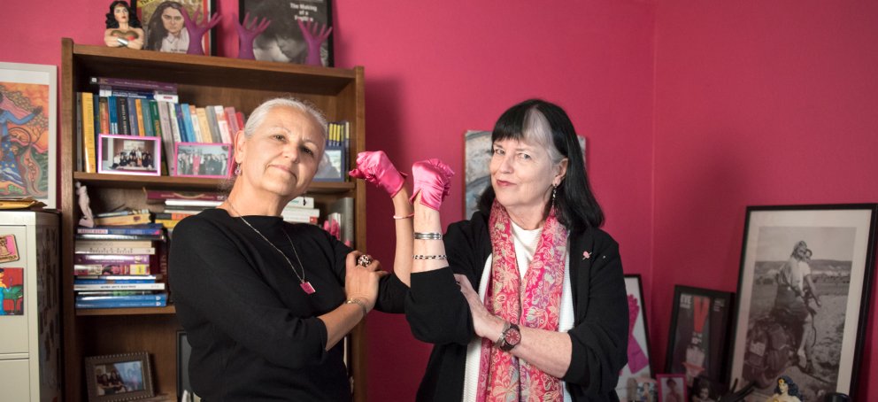 Two women's and gender studies professors holding up their fists to show power