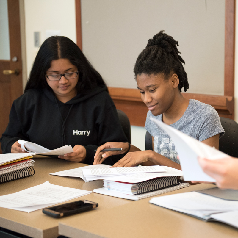 Students in class looking at their papers smiling