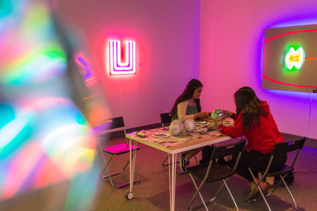 students making disco balls in the museum of art surronded by neon displays