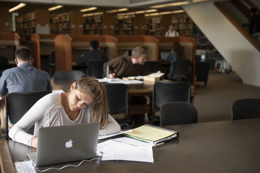 student writing in library