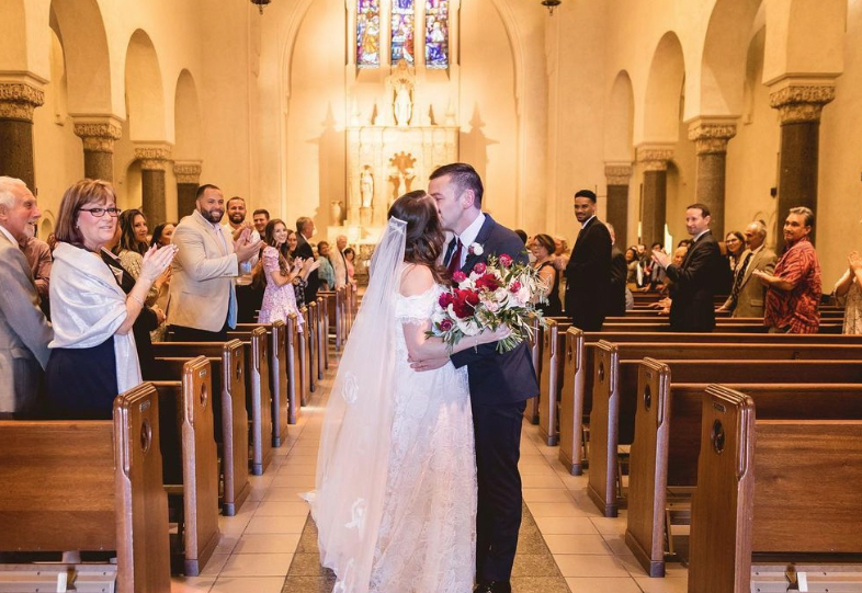 A wedding couple kisses in the chapel