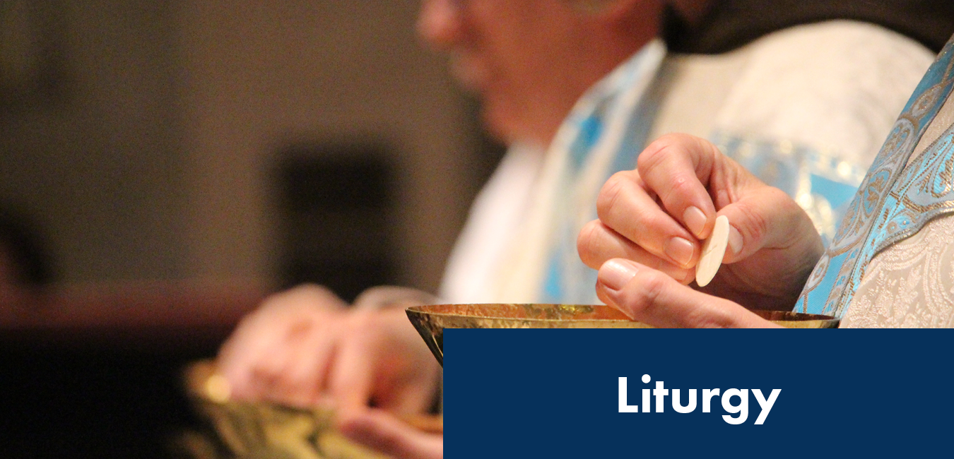 Image of a priest's hands serving a communion host at liturgy or mass
