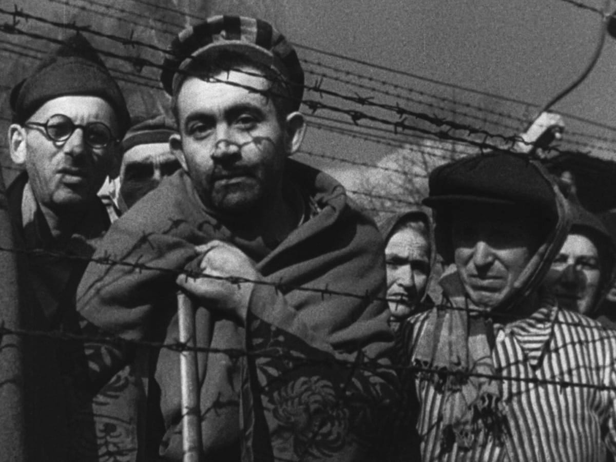 Shot from Night and Fog, prisoners behind a barbed wire fence