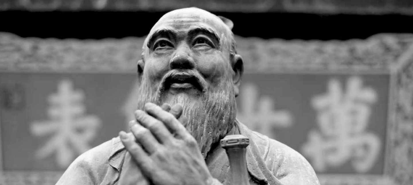 Confucius statue looking to the sky, hands clasped
