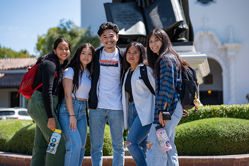 five students in front of statue outside