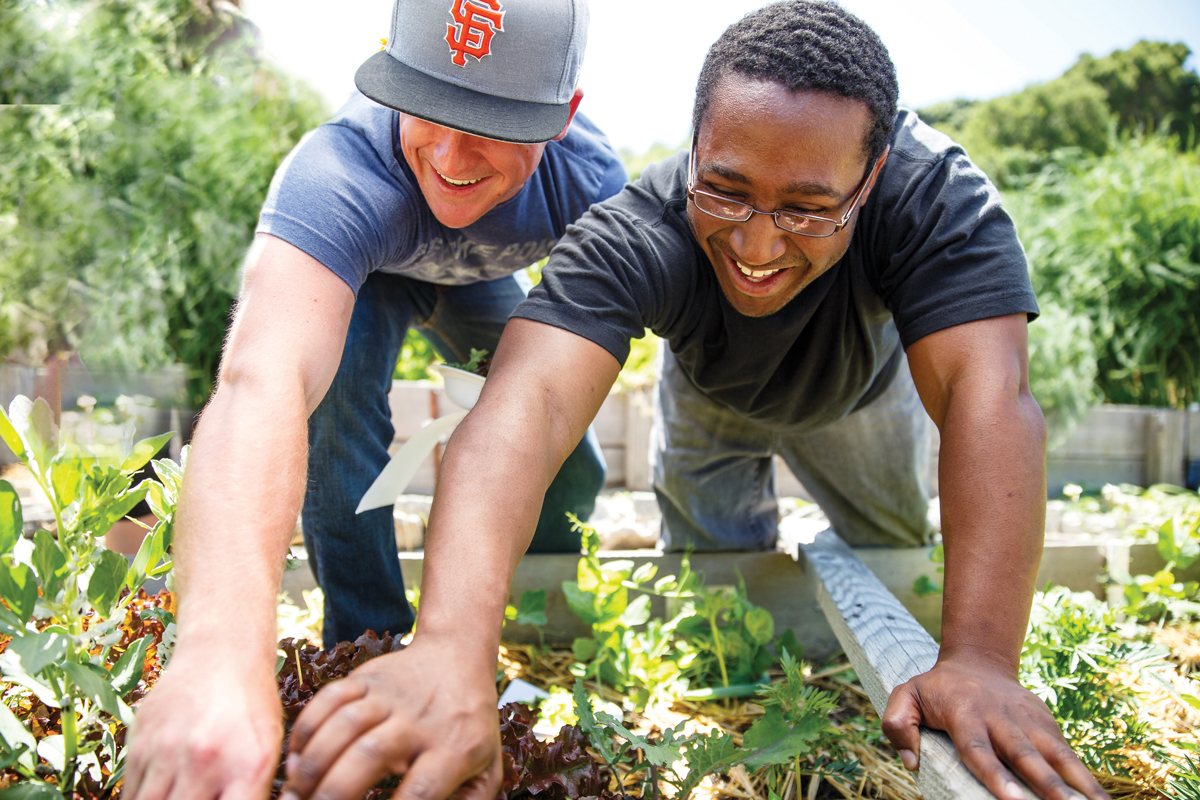 Students reaching for a strawberry laughing