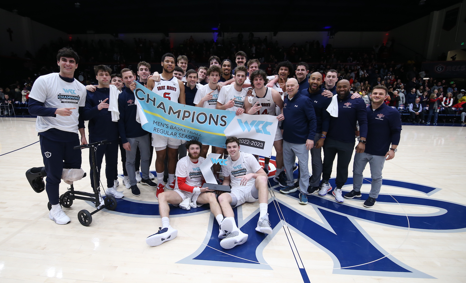 Gaels men's basketball poses with WCC trophy on February 23