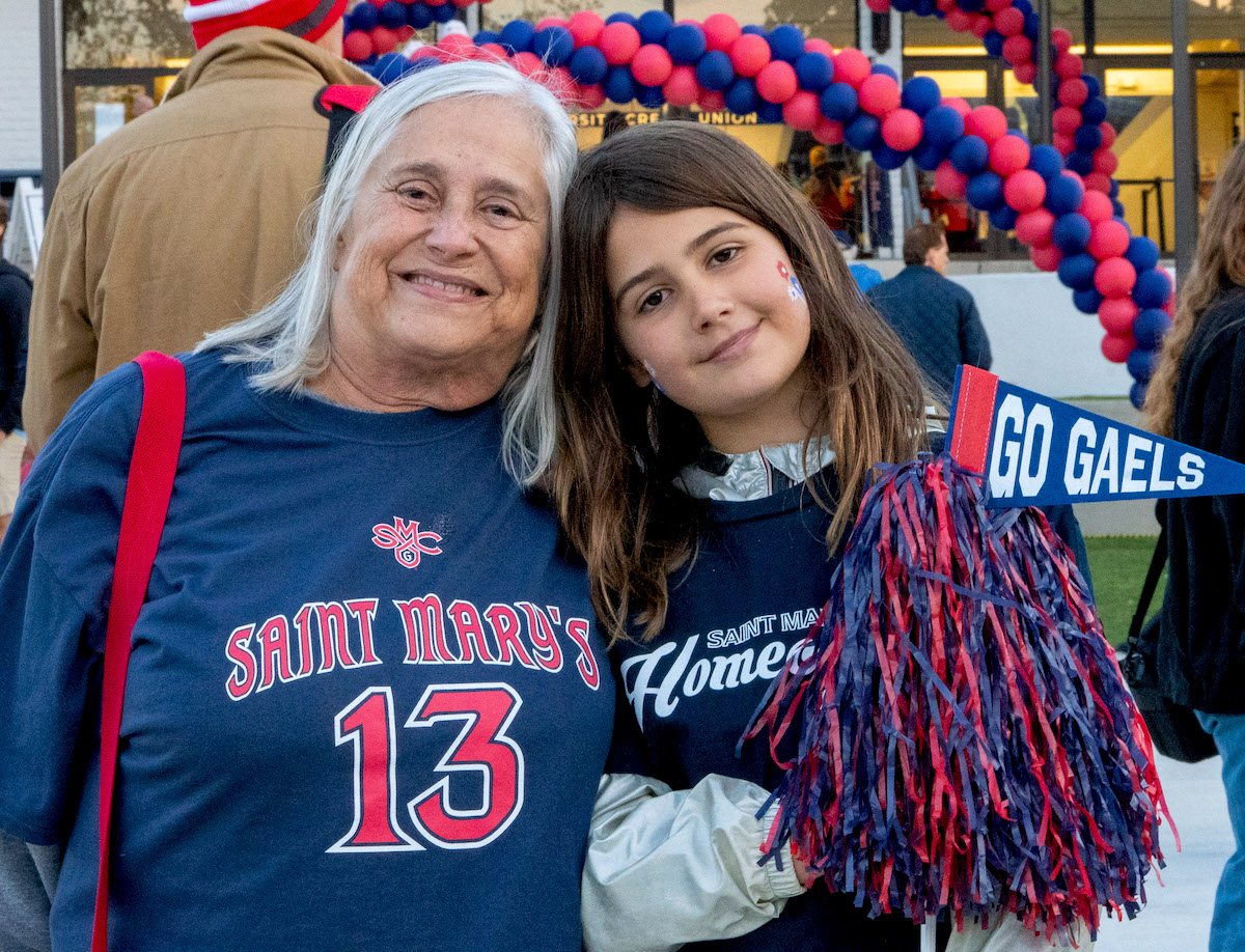 A grandmother and school-aged daughter smile in SMC clothes