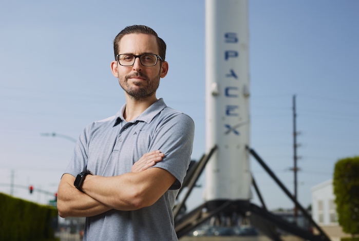 Alex Stillings in front of SpaceX rocket