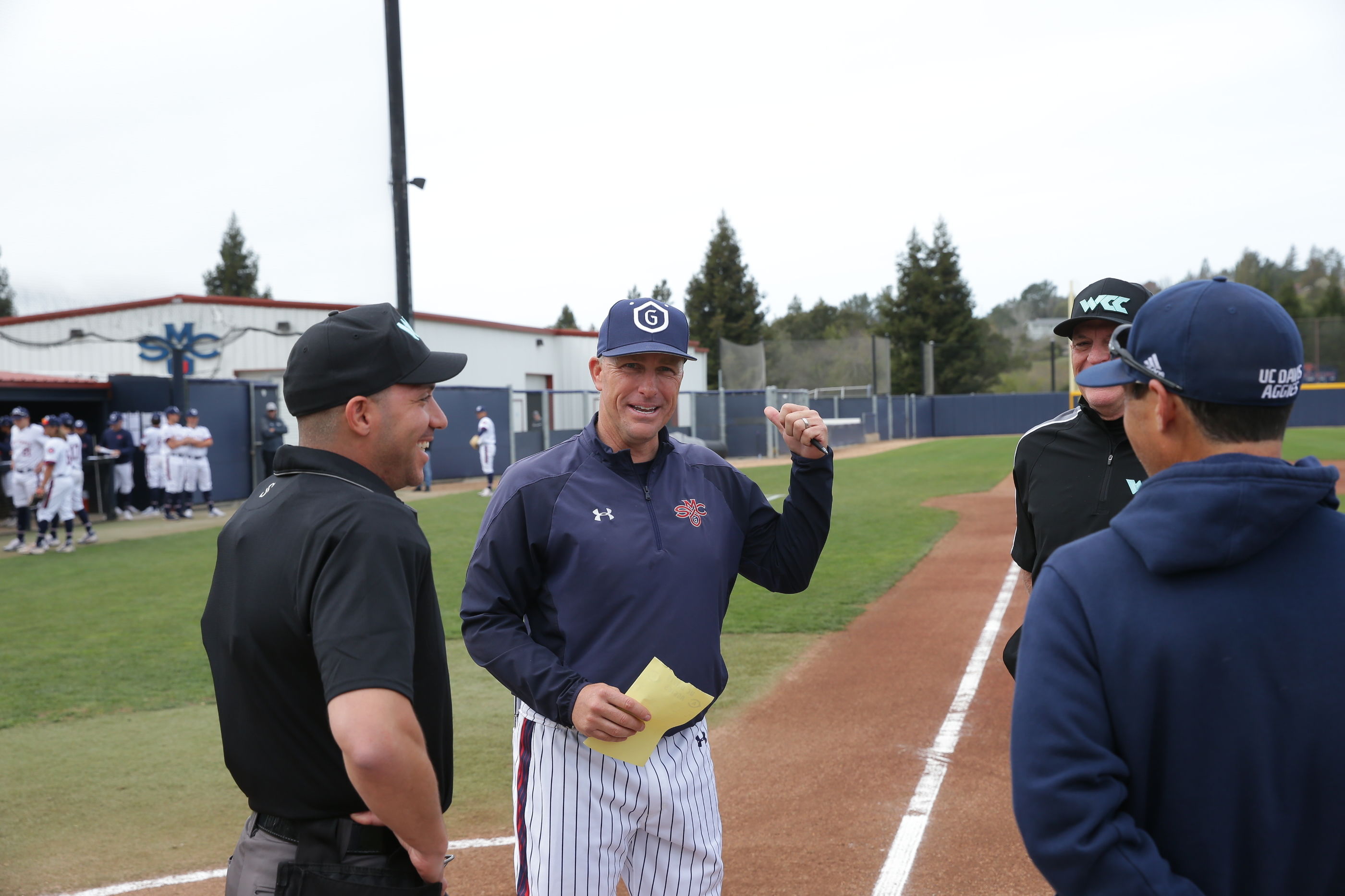SMC Baseball Coach Greg Moore meets with the umpires before a game