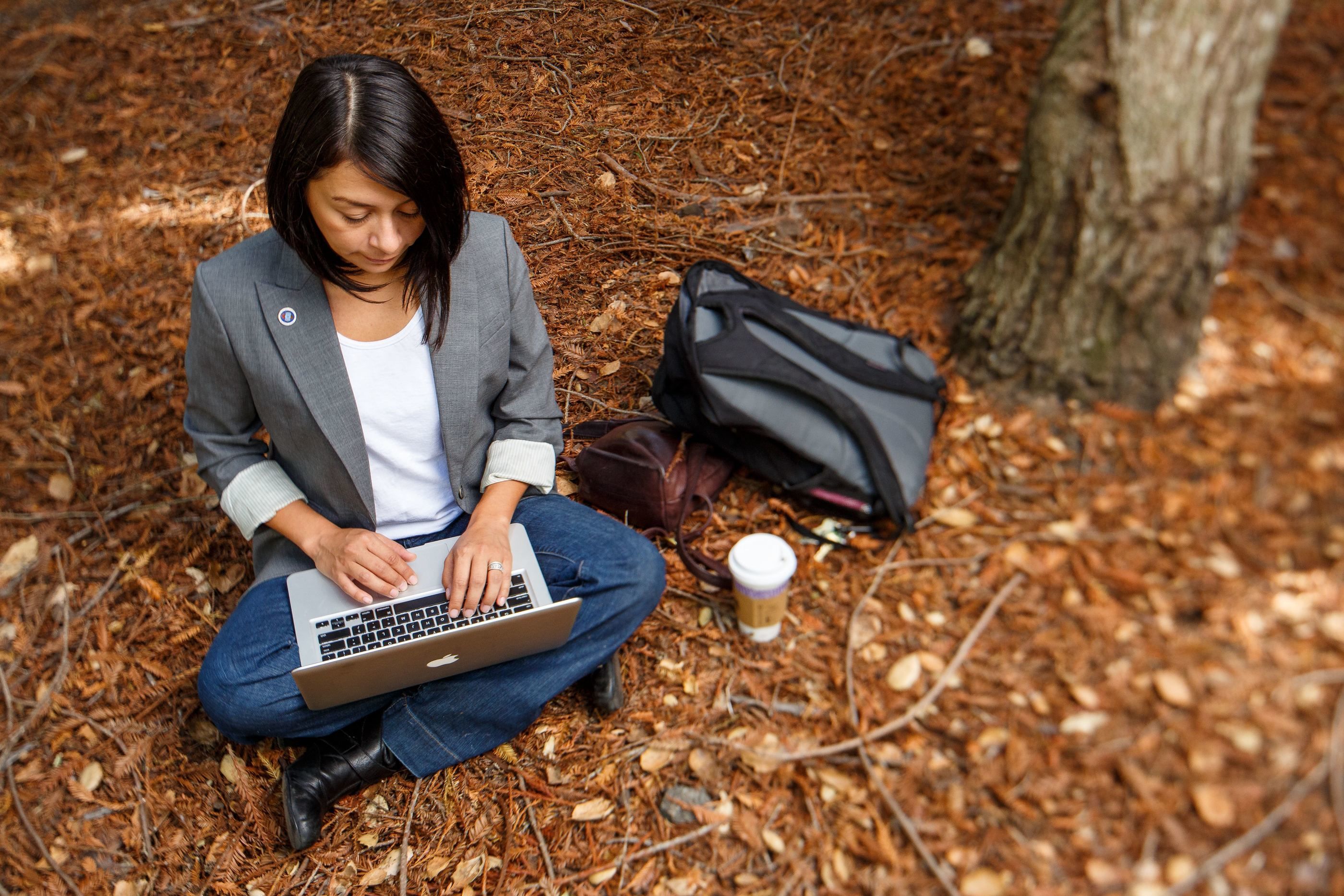 A student writes in the redwood grove.