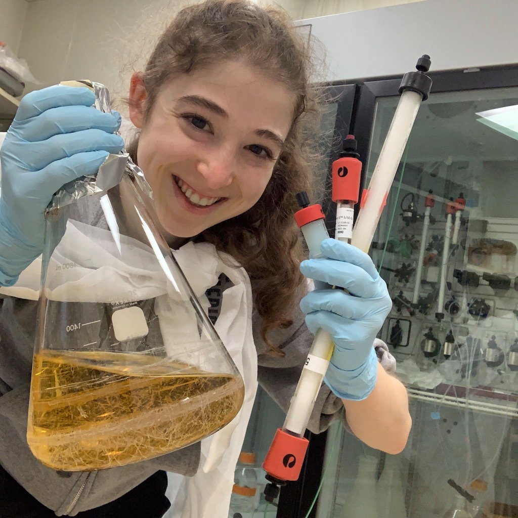 Brianna Bibel smiling and holding a beaker