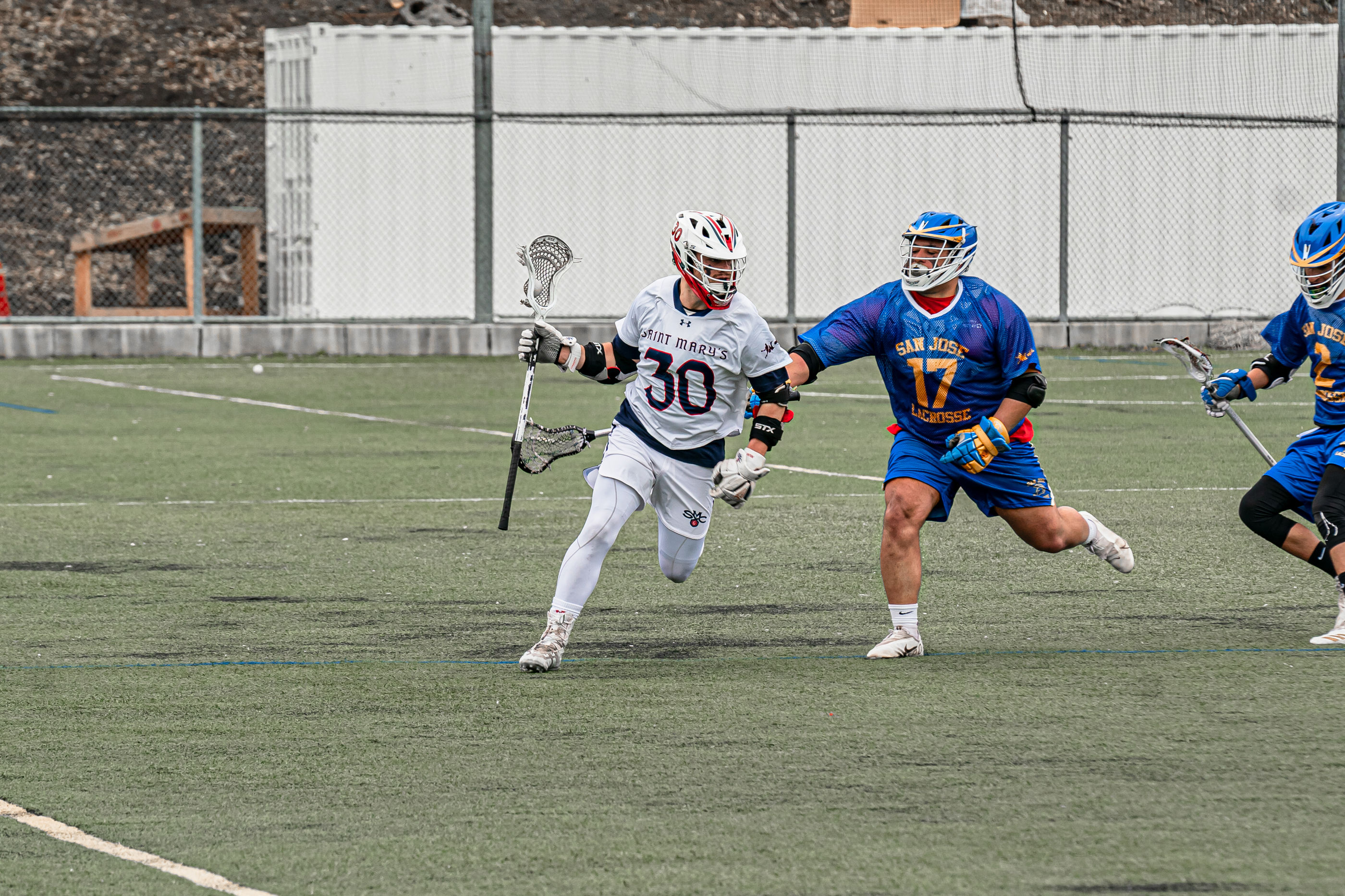 Men's Lacrosse Player running from defender