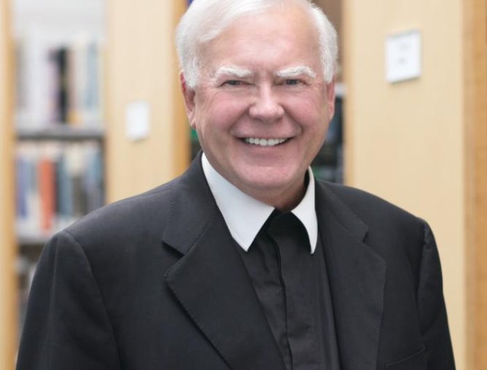 headshot photo of Br. Ronald Gallagher with bookcases in background