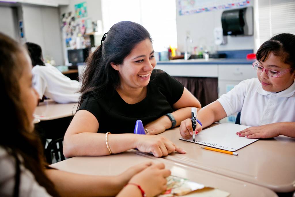 A teacher helping students at their desks