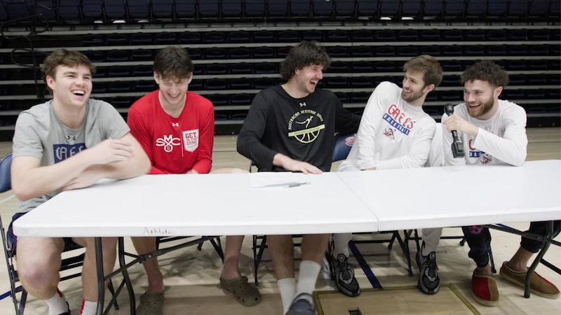 Five men's basketball players at a table