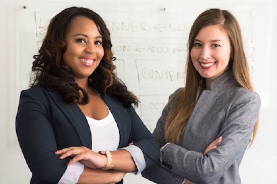 Two students in suits smiling