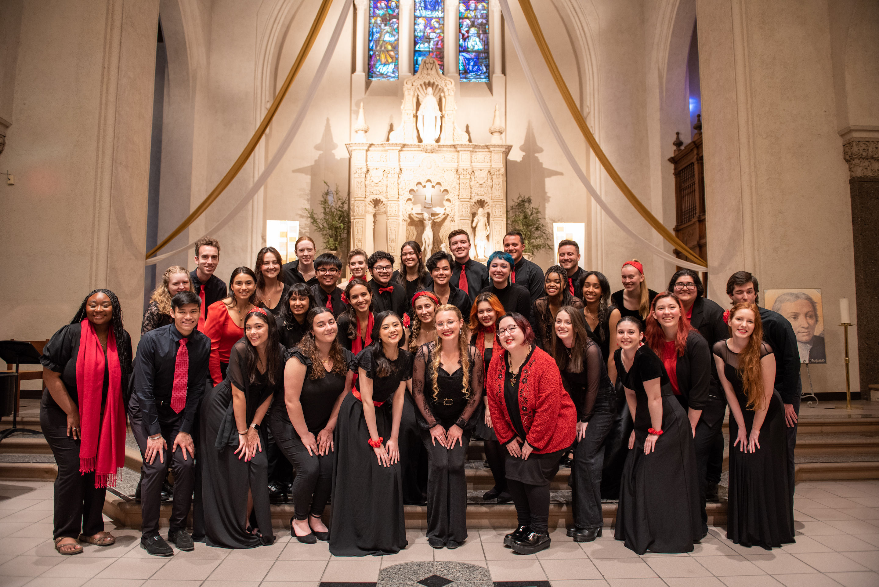 Members of SMC Choir in front of the Chapel altar posing for photo