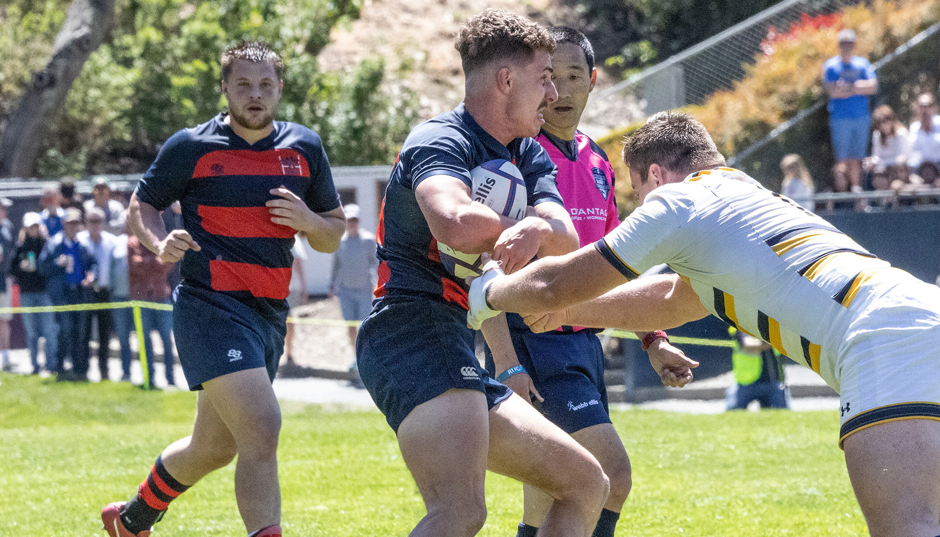 Men's rugby player Eric Storti pushes a UC Berkeley defender away to gain extra yards in an April 2023 playoff game.