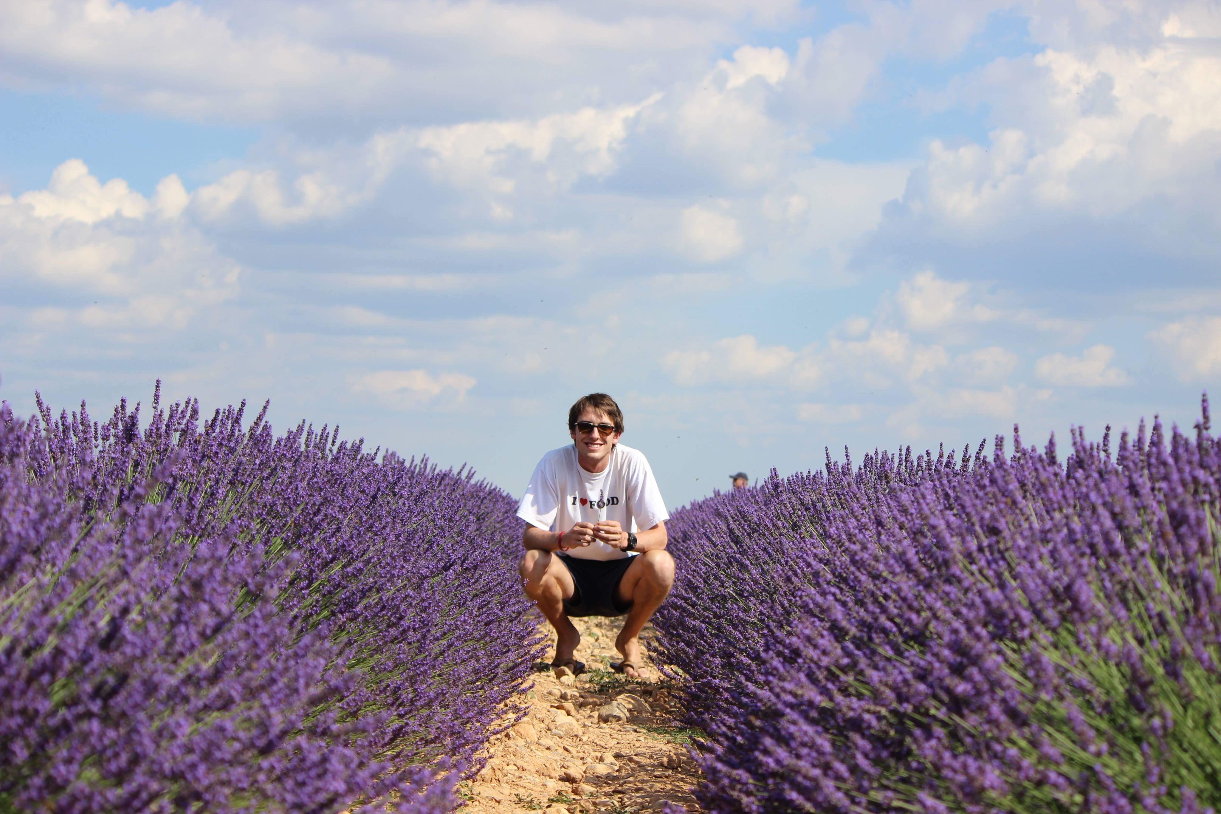 Student kneeling in lavender field in France