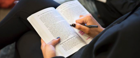 person taking notes in book close up