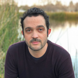 Headshot of Prof. Chris Arnold with a lake in the background