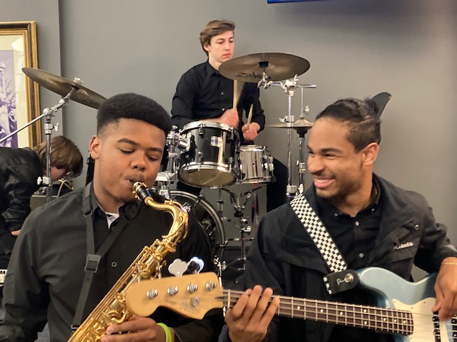 Jazz Band students playing drums, guitar, and sax in The 1928 Pub