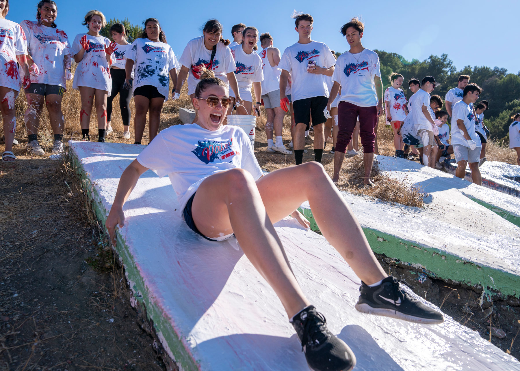 A student sliding down a letter at paint the smc