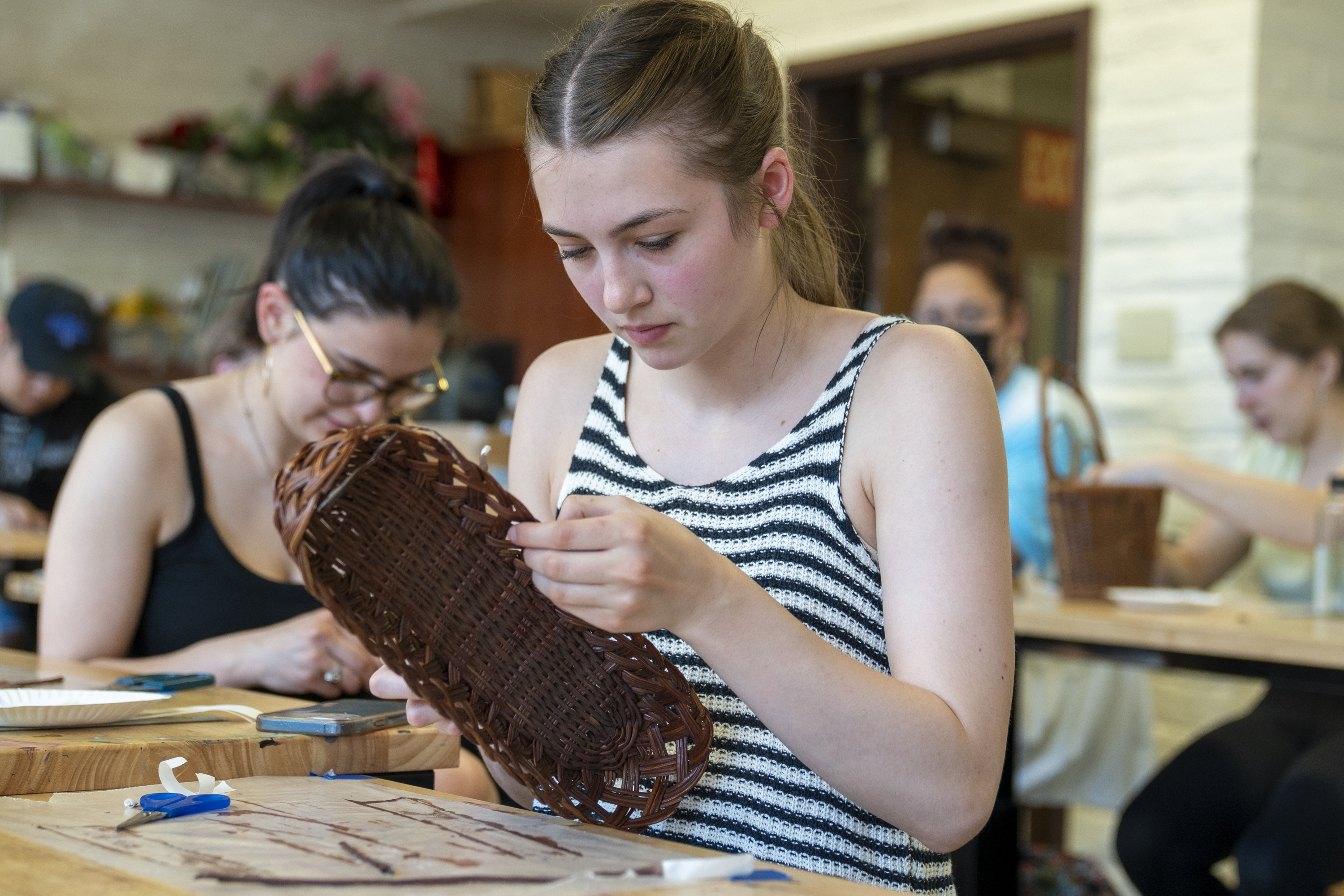 An Art Conservation student repainting a basket