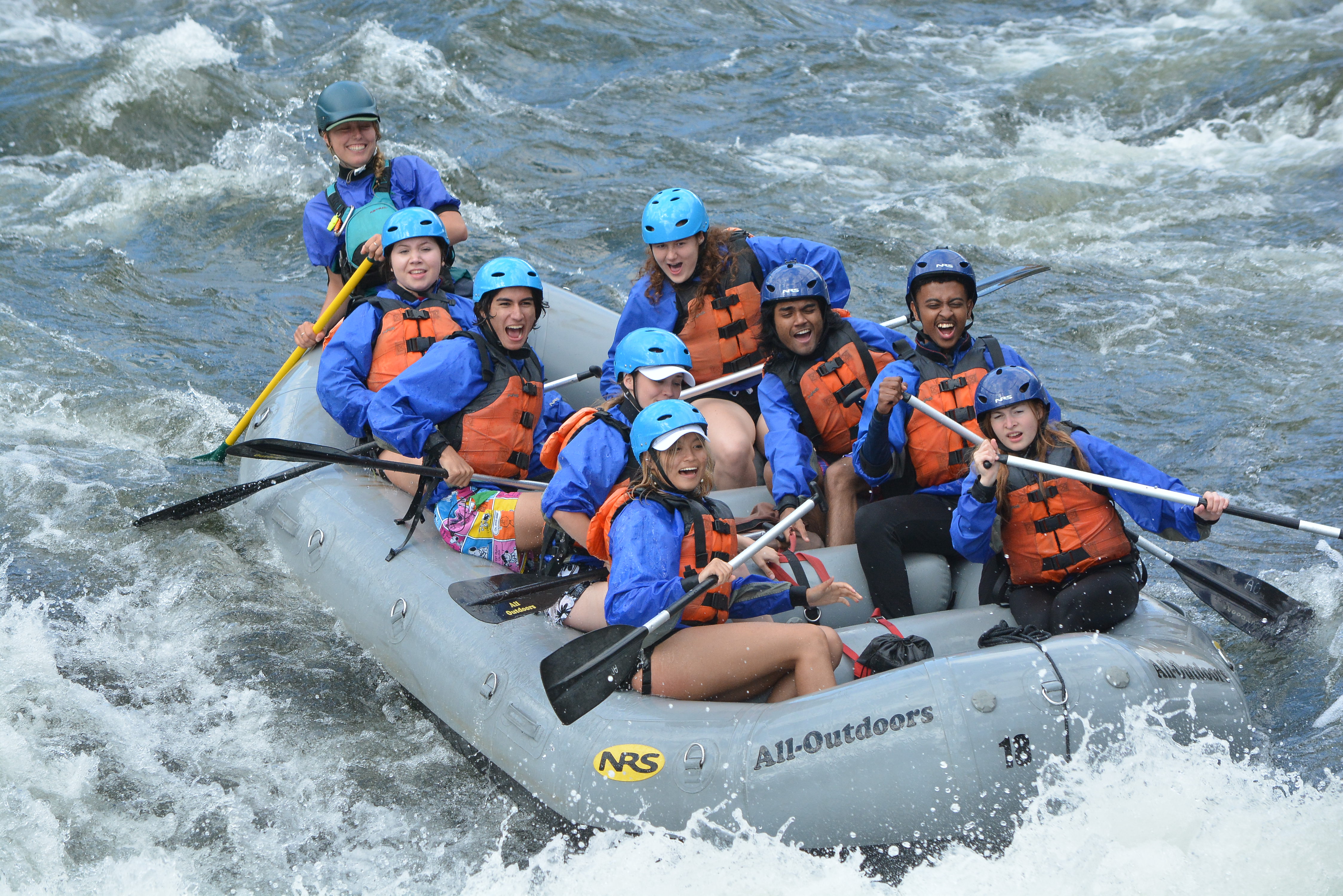 Student in rafting boats going down a rapid