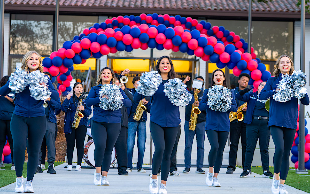 SMC Spirit team in front of a balloon arch