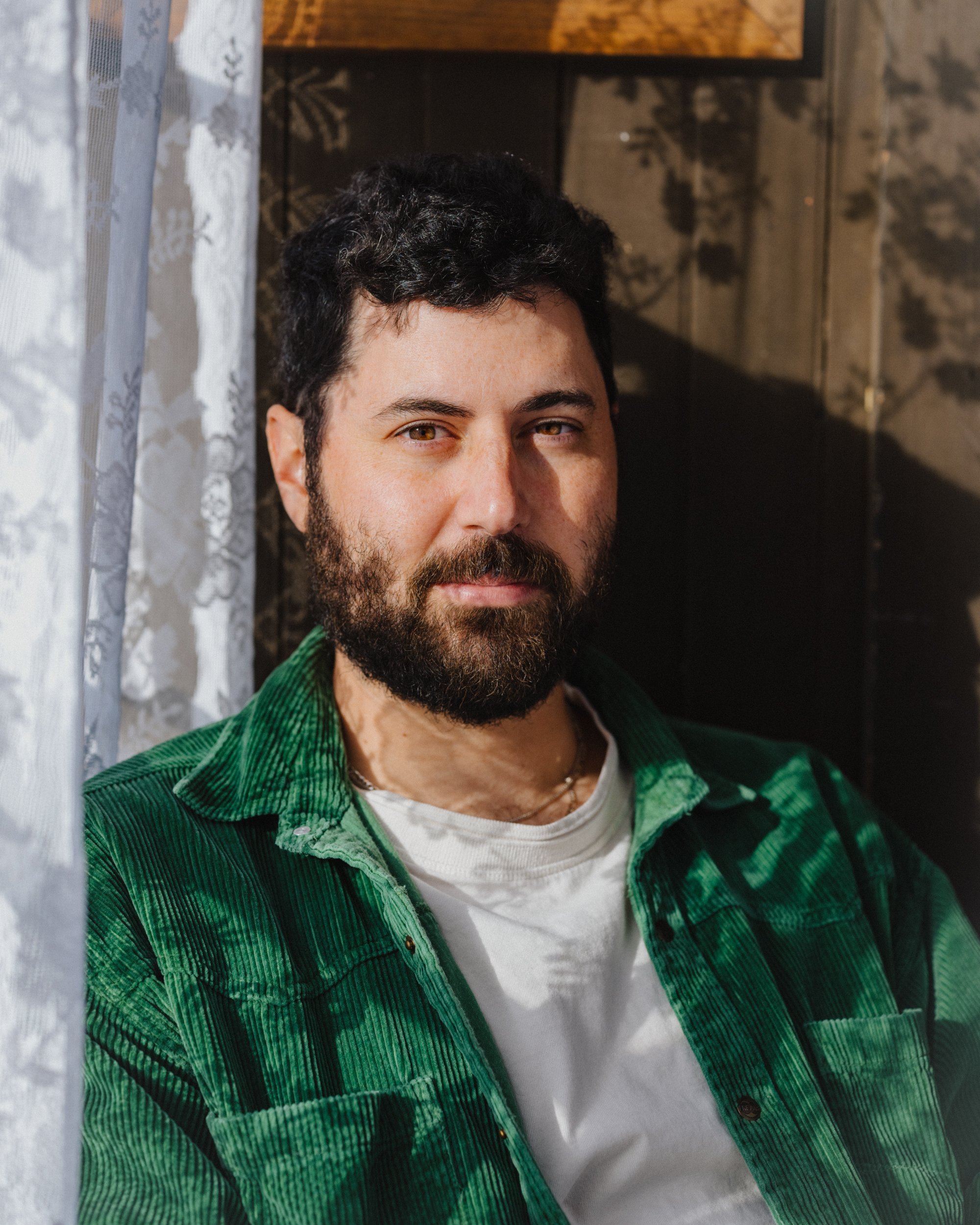 Headshot of Visiting Writer Daniel Gumbiner posing in a home.