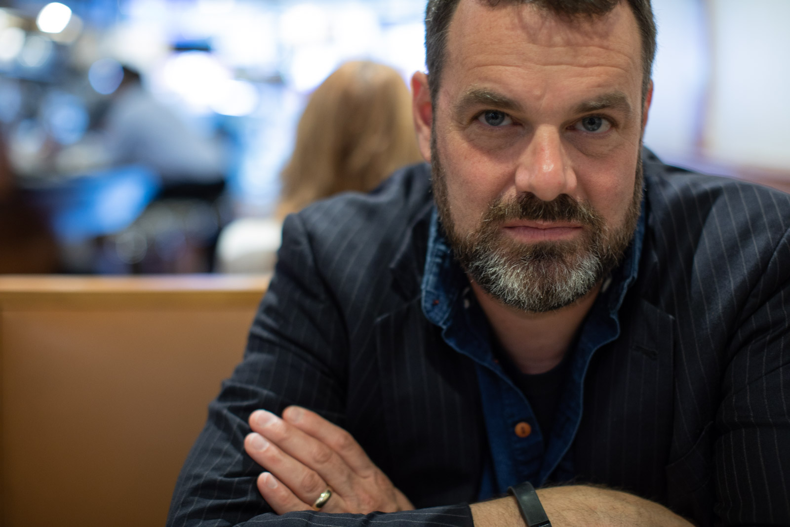 Headshot of Visiting Writer Grant Faulkner at a table with arms crossed.