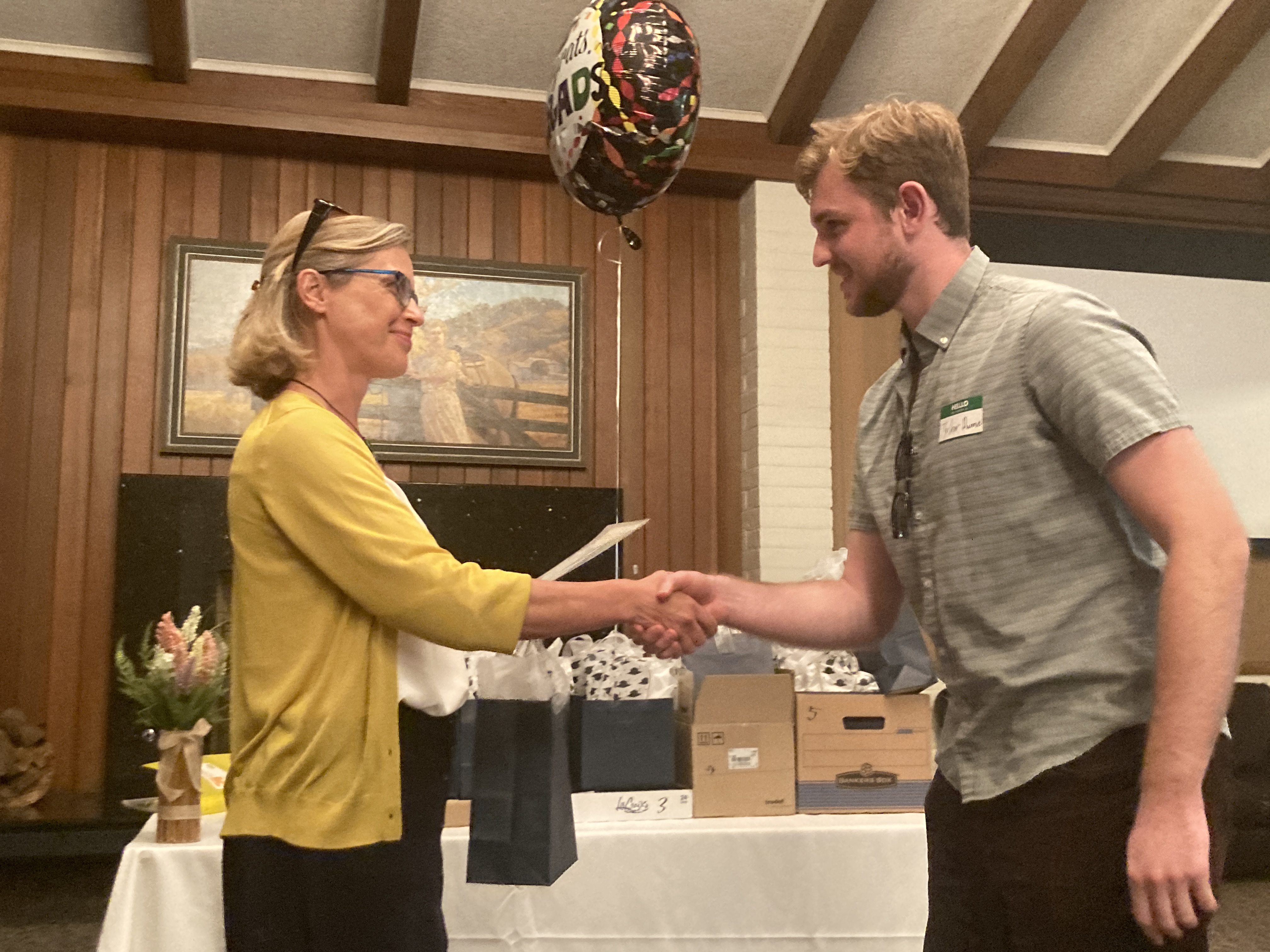 A student and a professor shaking hands in a ceremony