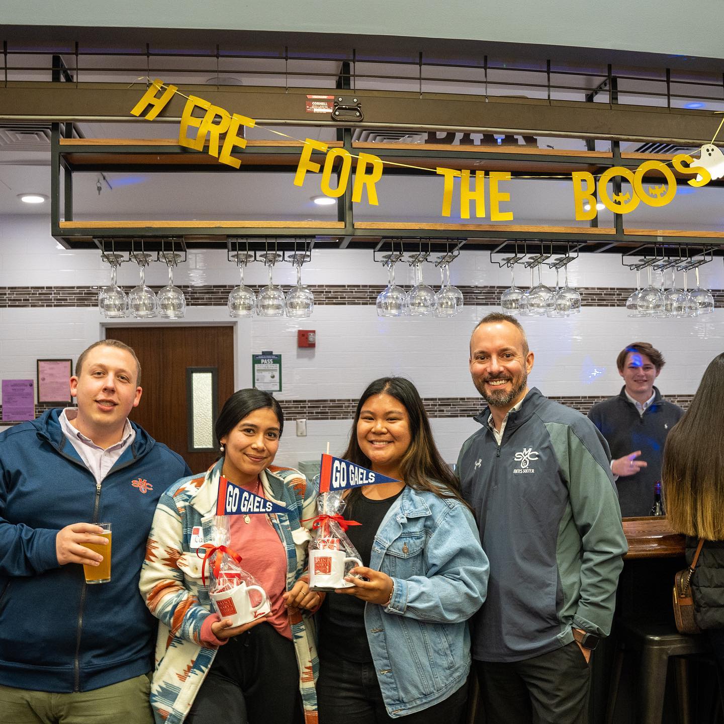 four alumni smile inside the pub