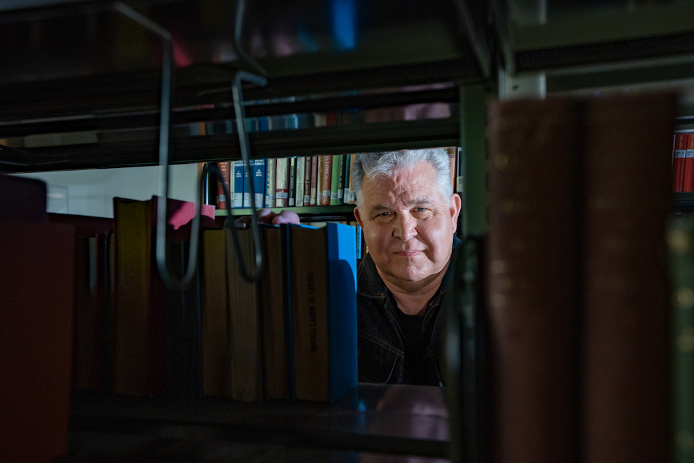 Librarian Norm Partridge looking through stacks
