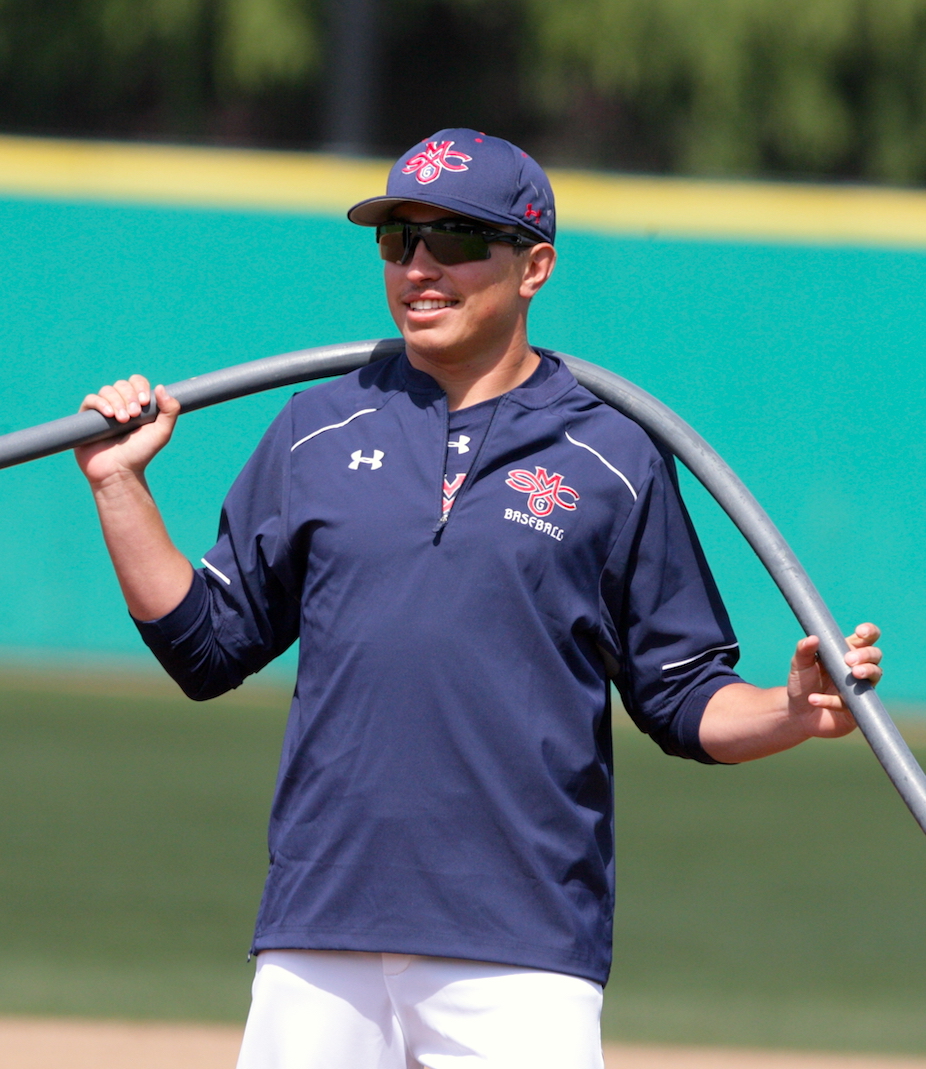 Max Molz lifts a hose before a baseball game at Saint Mary's Stadium