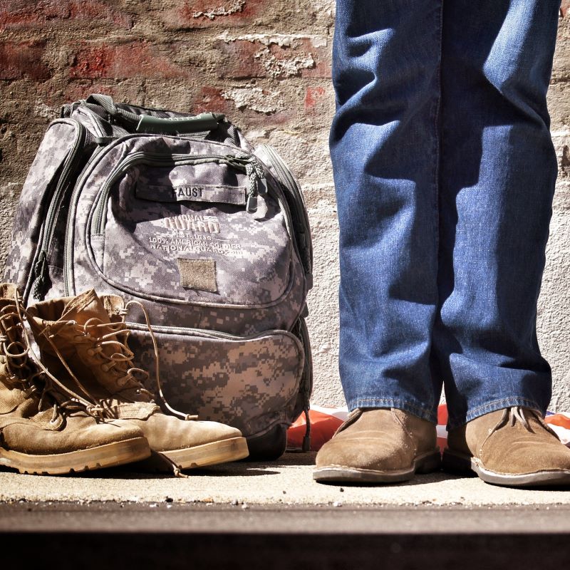 a military veteran standing next to books and backpack