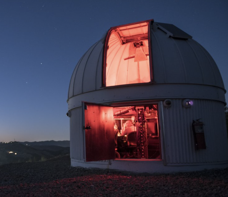 Observatory at night, illuminated by red light inside the dome structure