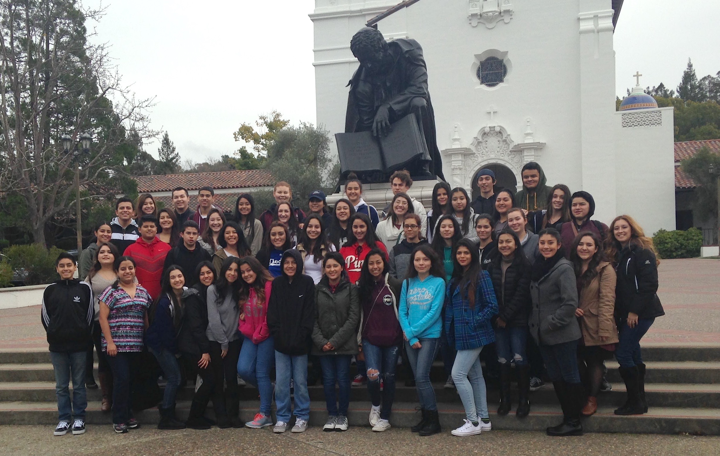 Dozens of high school students smile in front of the Saint Mary's chapel