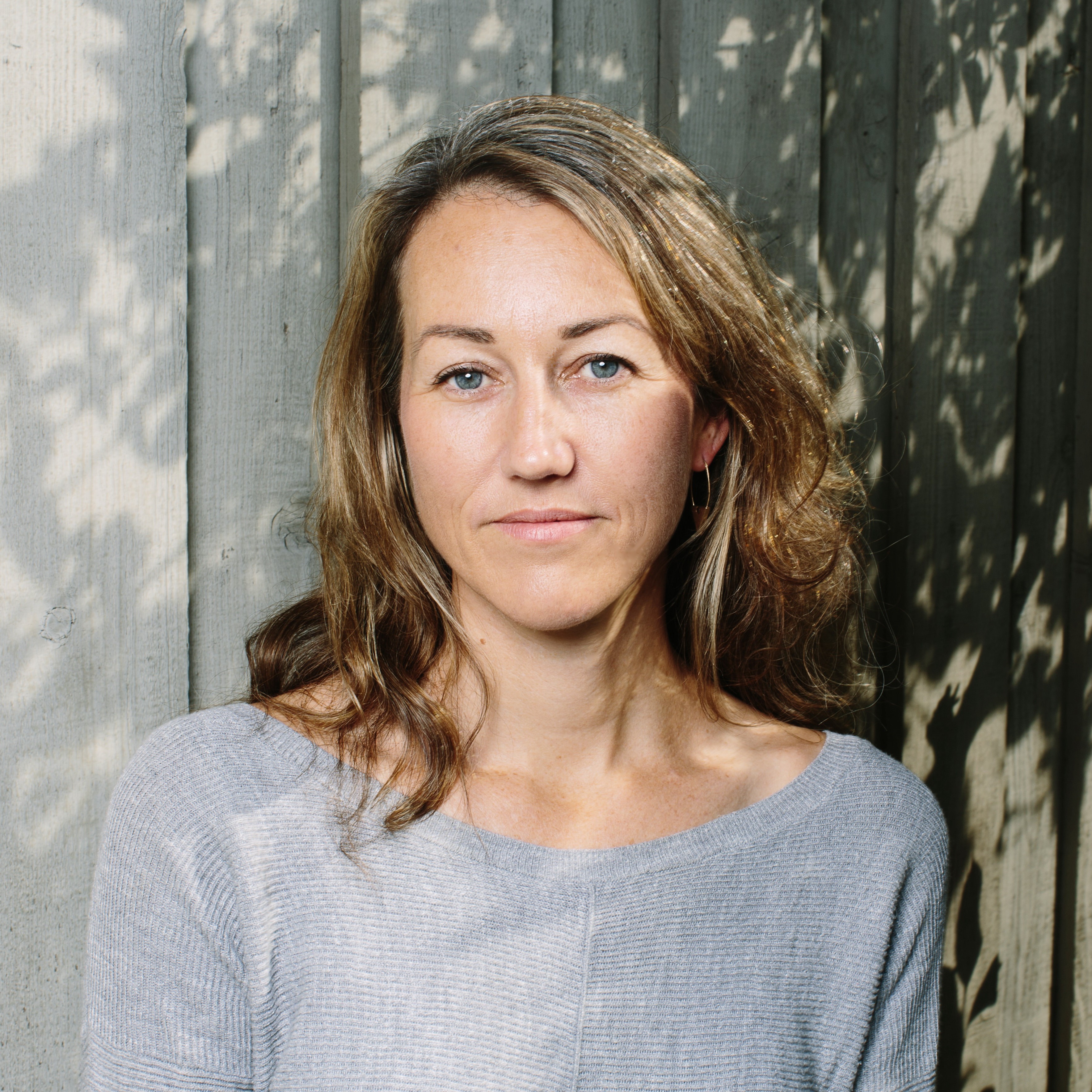 headshot of writer rachel richardson in front of a shadowy background