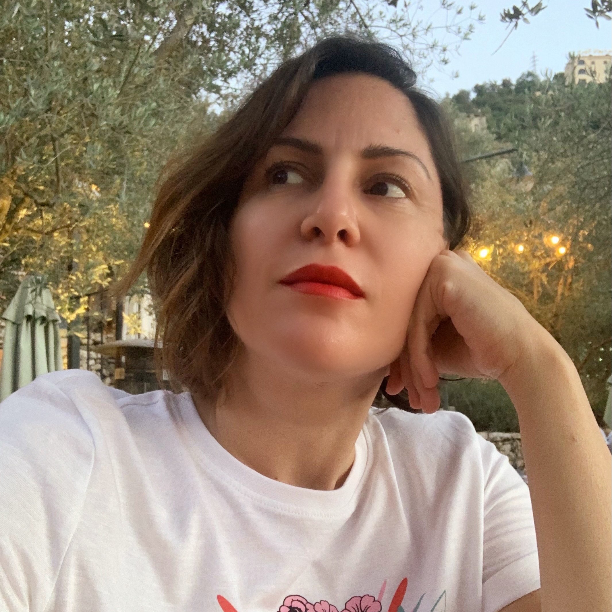 headshot of zeina looking contemplative in front of an outdoor setting