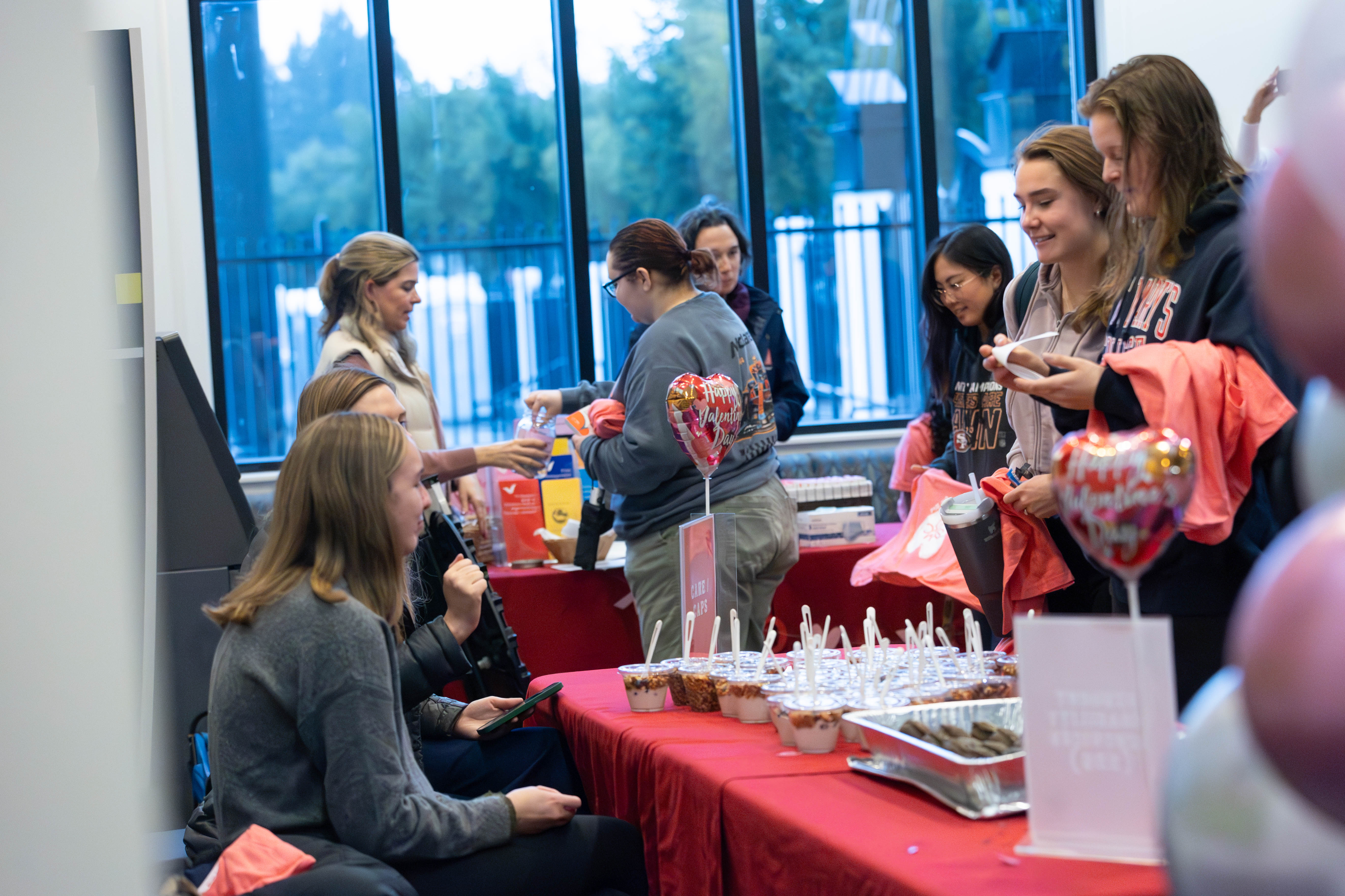 Treats & Resources: Students gather treats and resources from SDS, CAPS, CARE & Health Center Tables during the LoveWell event on Feb 14th that promoted self care and compassion on Valentine’s Day. / Photo by Rebecca Harper