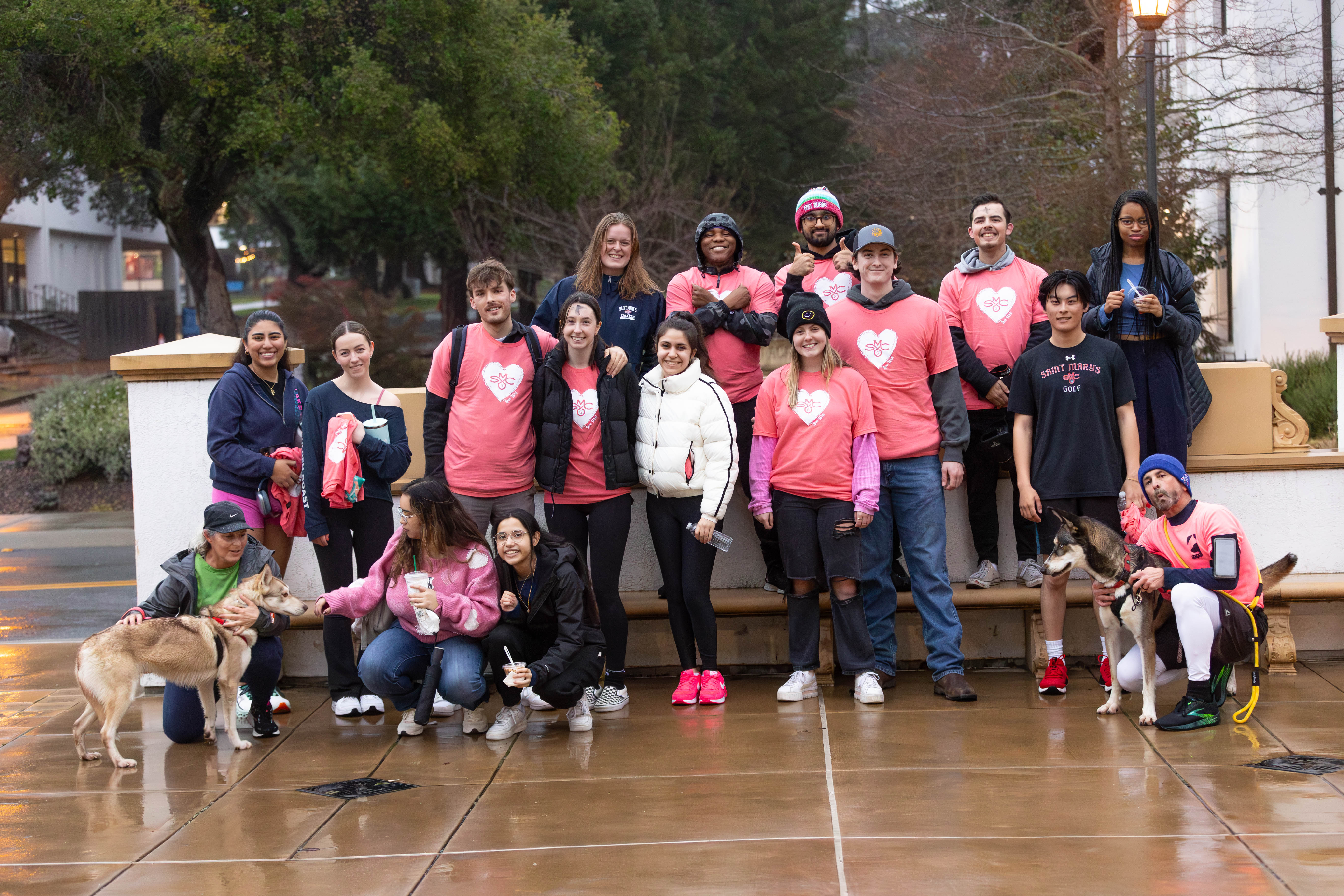 SWEAT: Participants gather together with rescue pups from Contra Costa Animal Services to take a group photo with rescue dogs Bailey (left) & Freesia (right) after the jog around campus. / Photo by Rebecca Harper