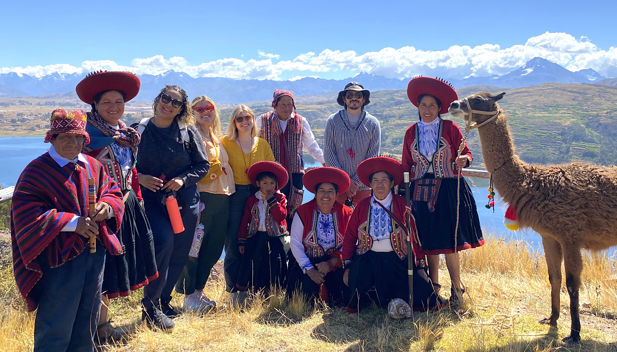 Saint Mary's alumni and Peruvians on a ridge with a llama