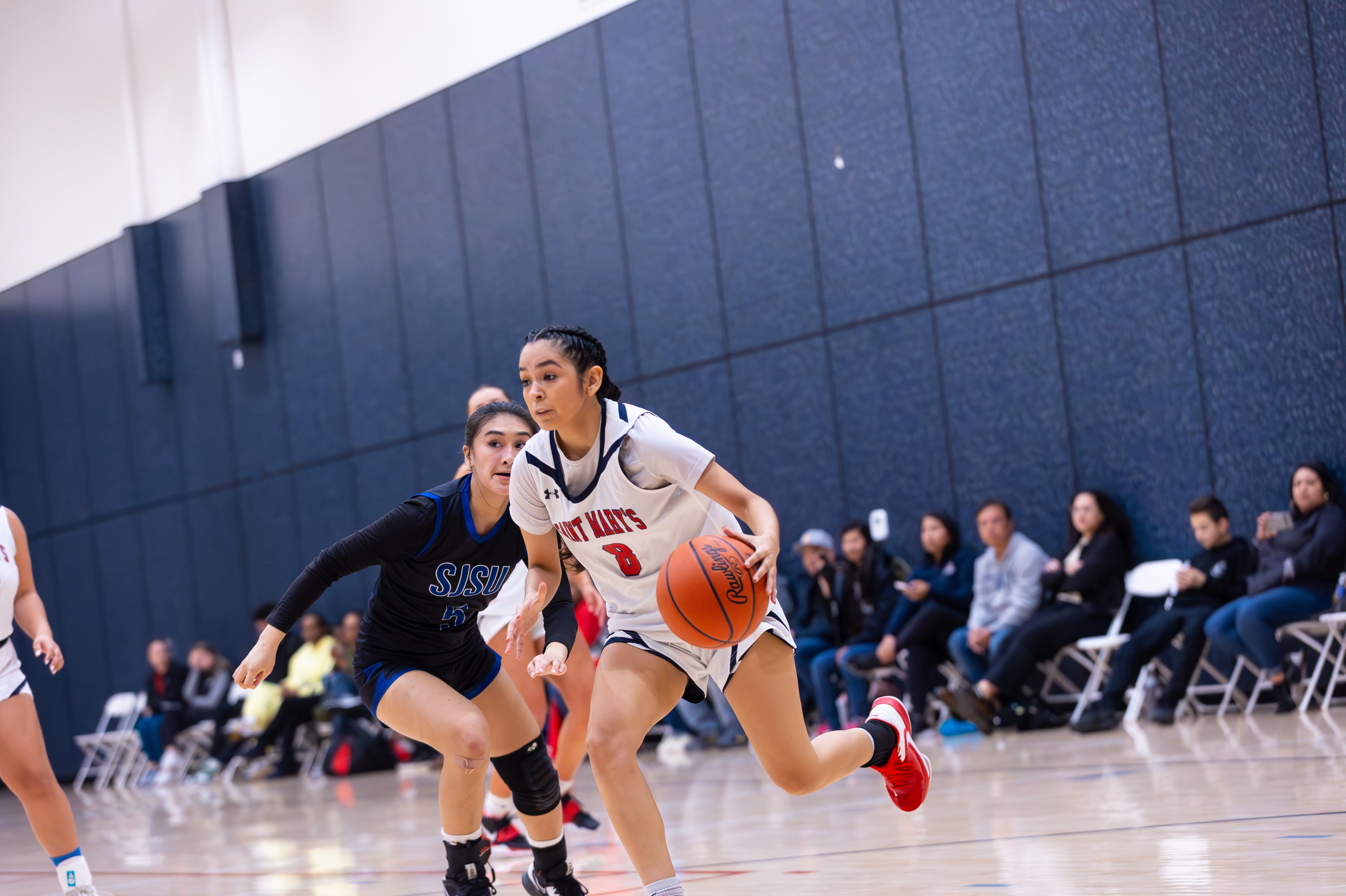 To the Hoop: No 8 Chloe Aguilar dribbles against the San Jose State Opponent on Feb 17 to shoot a layup at the Joseph L. Alioto Recreation Center in front of family & friends who came out to support the first home game for the team.