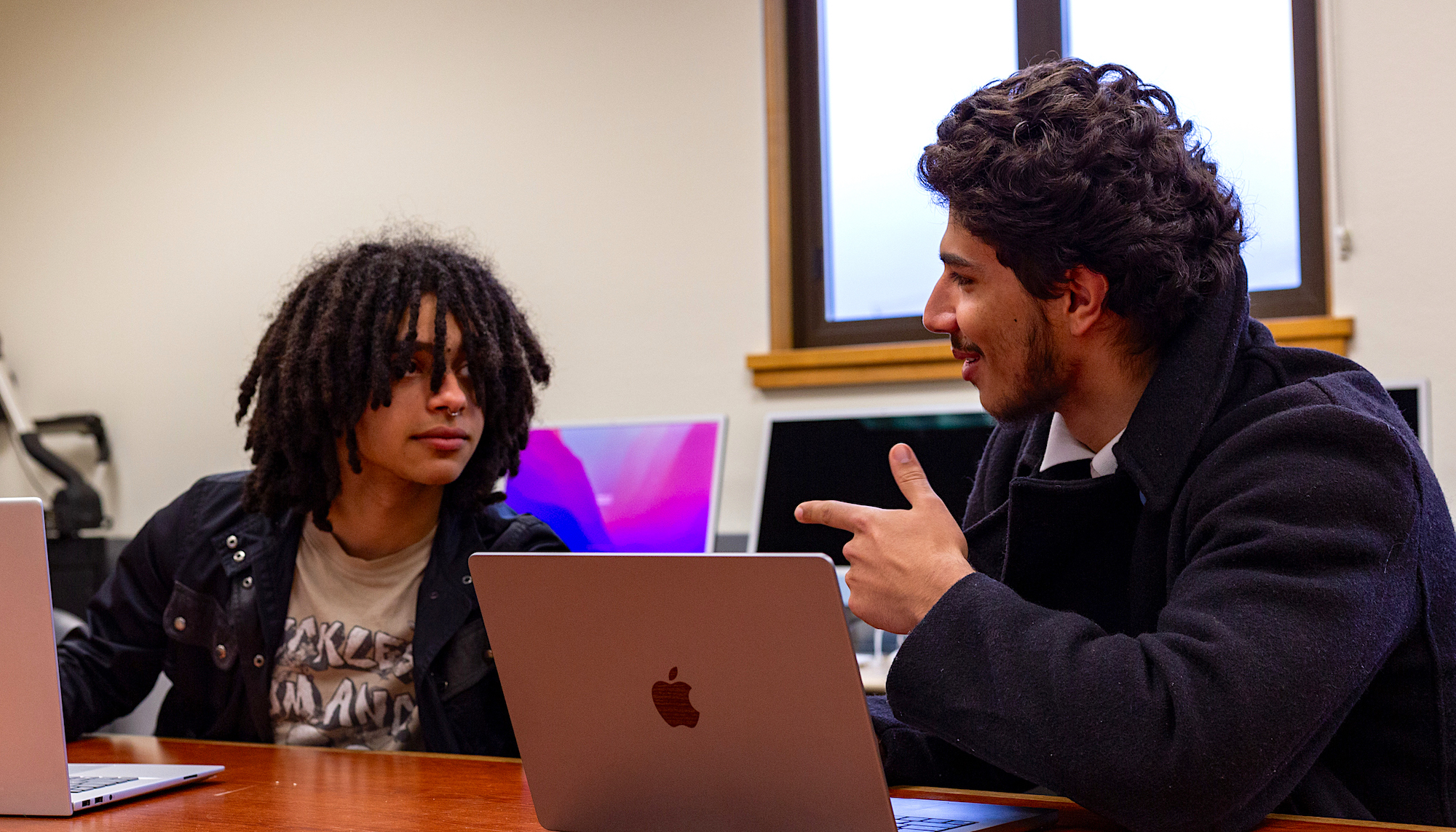 SMC students Jasper Pacheco ’27 and Luis Mora ’27 talking at table with computer for debate practice, 2024