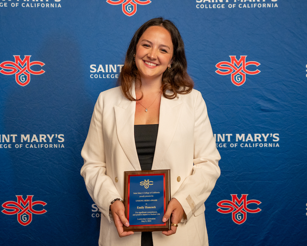 Emily Hancock holds up a plaque for 2024 Student Leadership Awards