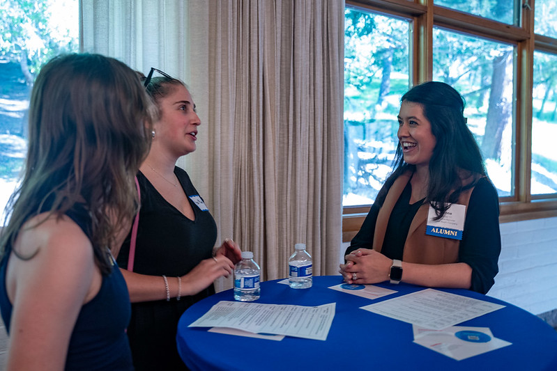 Young alumni networking and conversing around a table